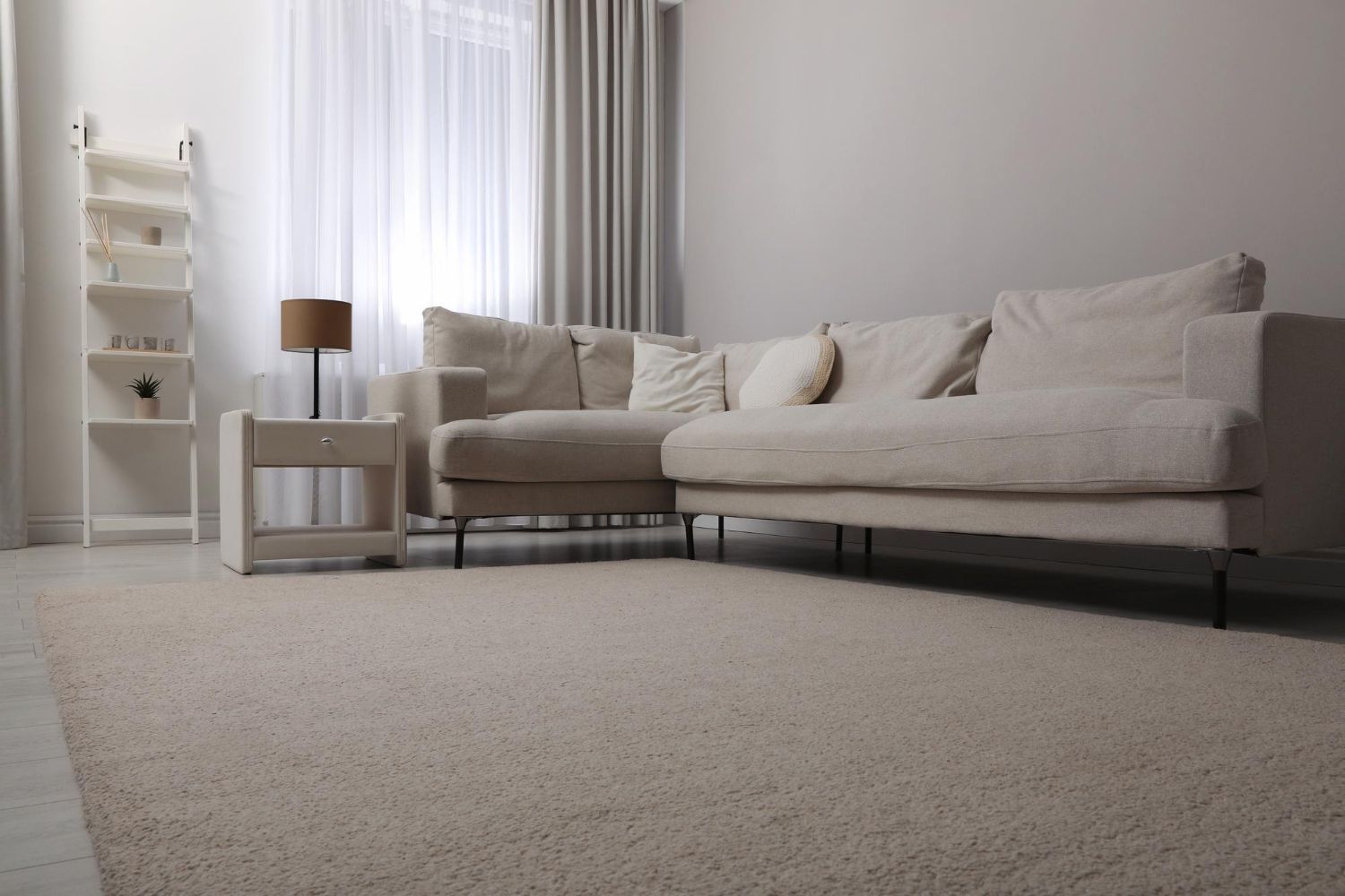 Clean cream carpet in a bright living room with a sectional sofa